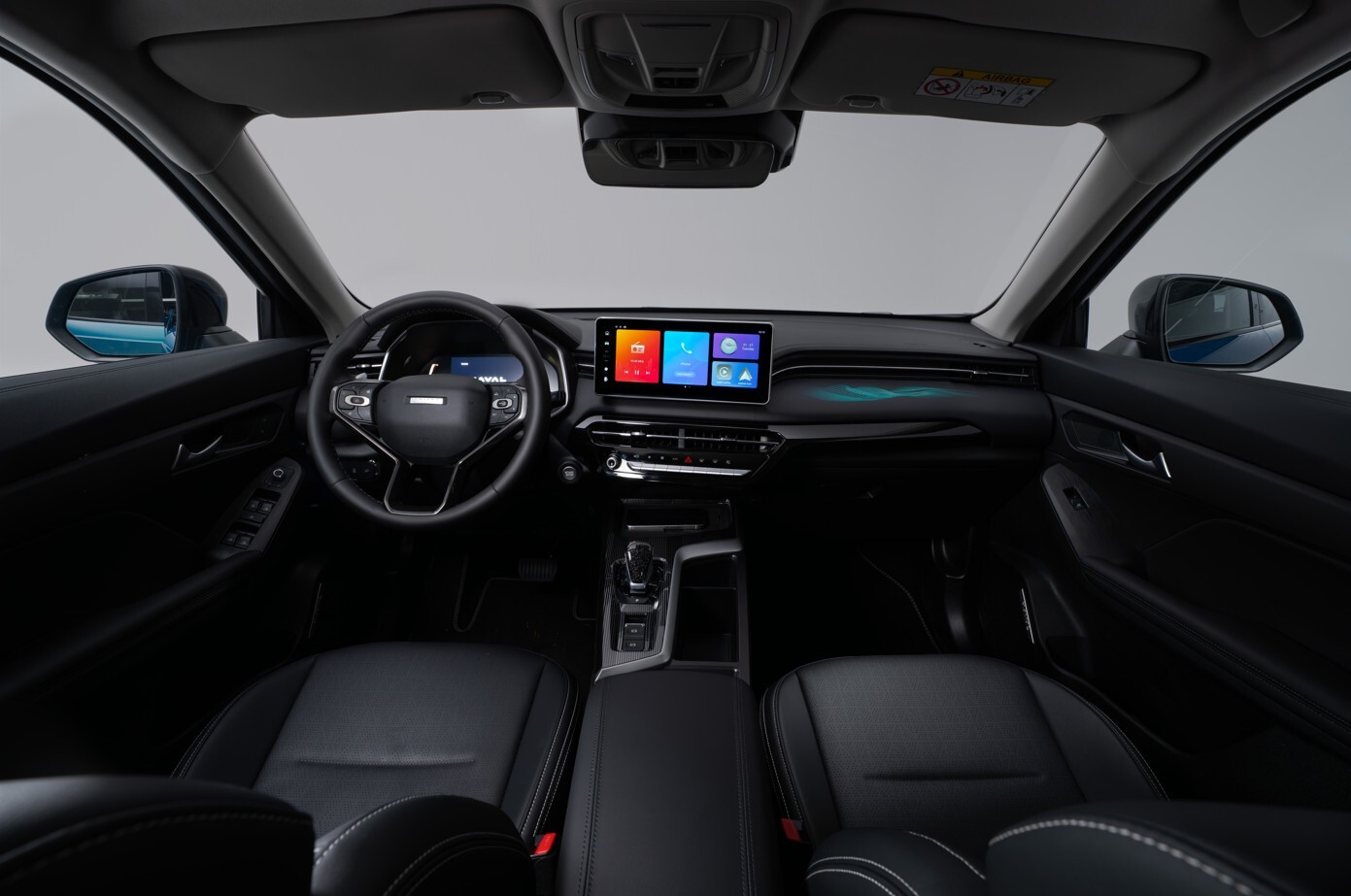 Innenraumansicht eines GWM Jolion Pro von der Rückbank aus, mit schwarzem Cockpit, digitalem Kombiinstrument, großem zentralen Touchscreen und schwarzen Sitzen mit heller Kontrastnaht.