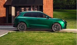 GWM ORA 5 SUV, Seitenansicht, parkend vor einem modernen Gebäude mit Rasenfläche